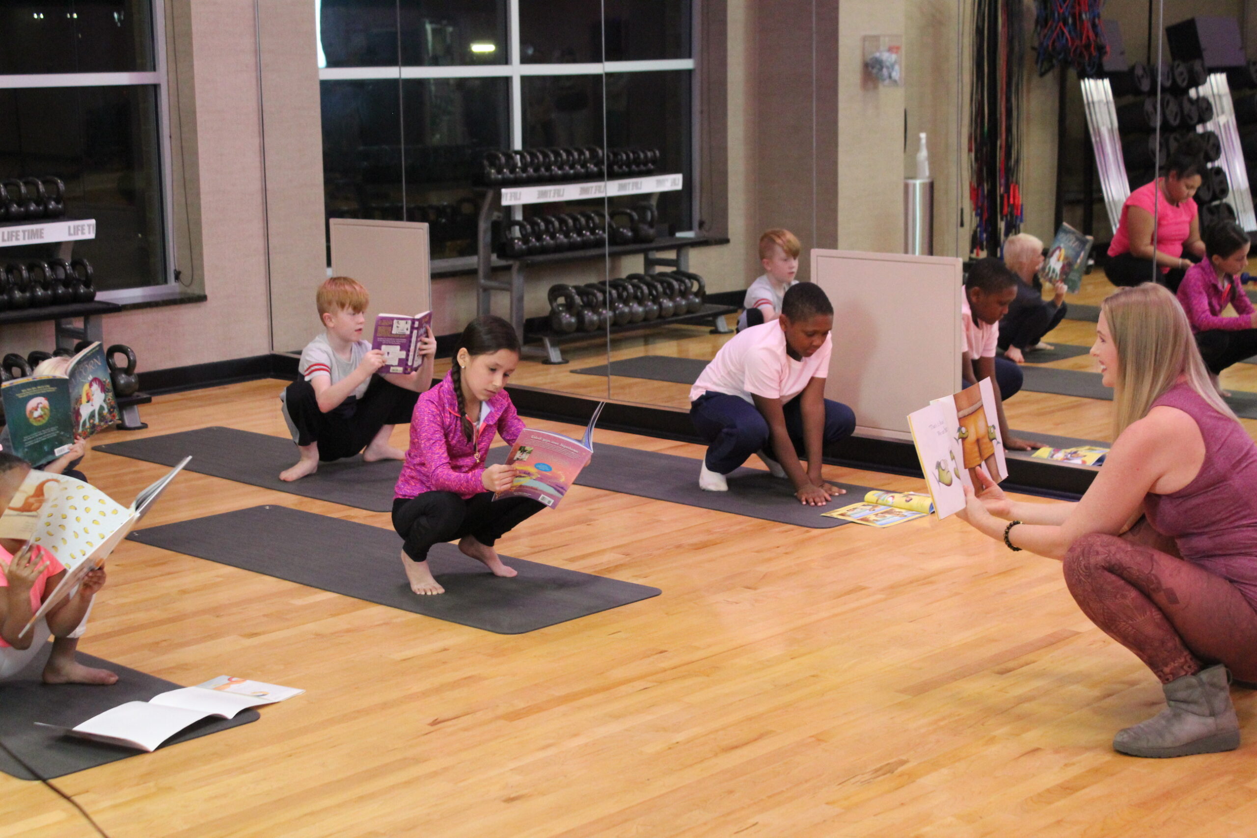 Class reading while doing yoga in LiYo Literacy Yoga Fusion Poses
