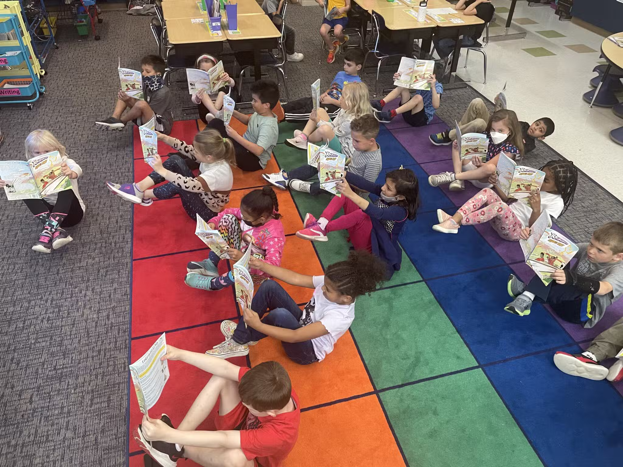 Classroom of children reading in LiYo Flying Pretzel Monkey Pose. 